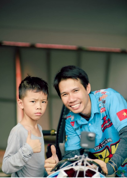 Cậu bé Ngô Nguyễn Việt Tuấn bên cạnh cha, Ngô Nguyễn Anh Tuấn, cũng là người huấn luyện viên đưa em đến với đam mê đua môtô thể thao. Ảnh: nhân vật cung cấp